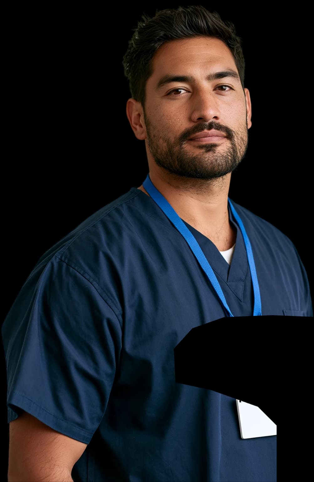 A nurse in navy scrubs wearing a blue lanyard, looking to camera